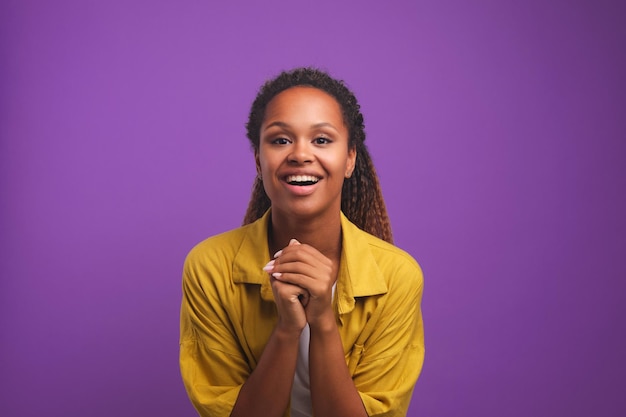 Overjoyed young african american woman in pose gratefully human stands in studio