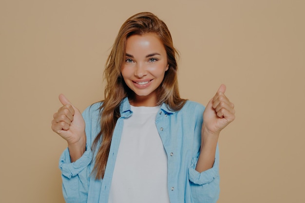 Overjoyed young european lady clenches fists with triumph