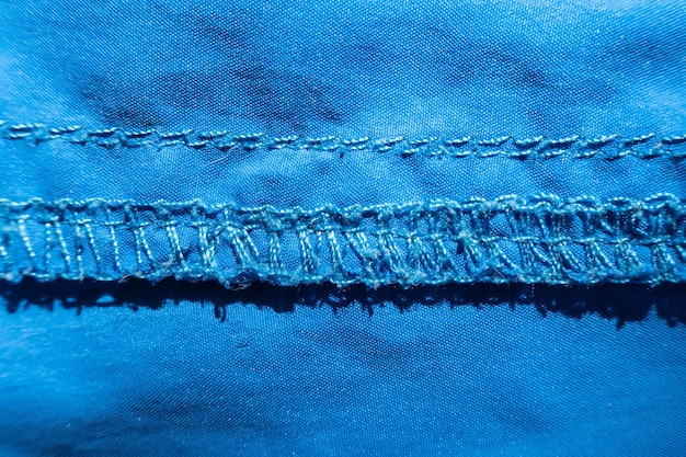 Overlock seam on blue synthetic fabric