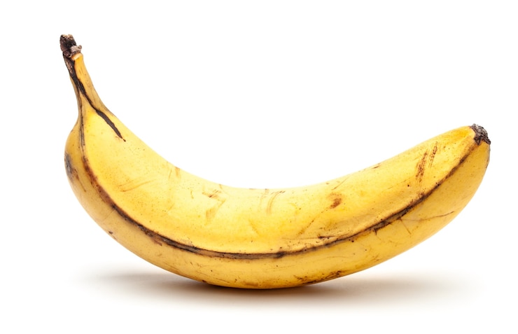 Foto overrijpe oude banaan. gele banaan met zwarte stippen. geïsoleerd op een witte achtergrond.