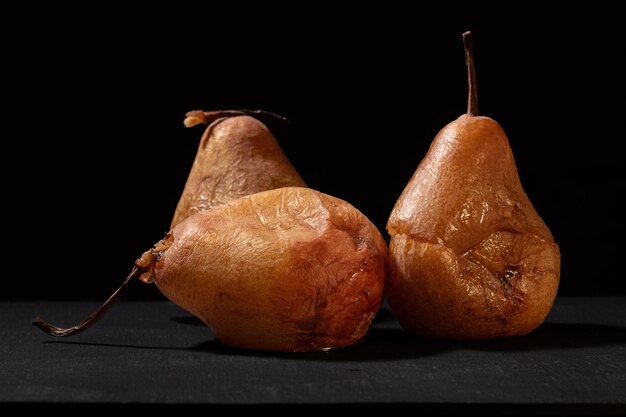 Overripe pears with black background and warm lighting