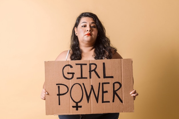 Photo oversized latinx woman looking away and smiling with girl power banner over