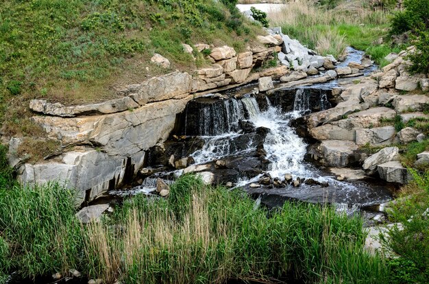 Overstroomde industriële granietcarrière met watervallen