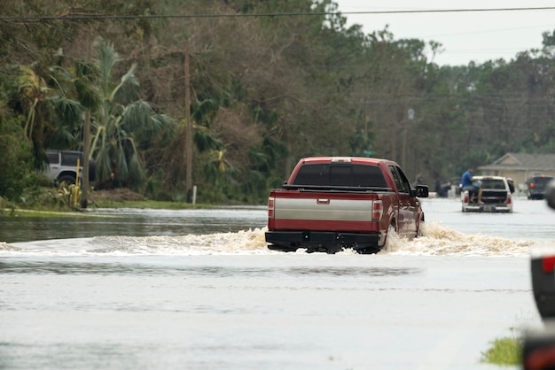 Overstroomde straat na orkaanregen met rijdende auto's in een woonwijk in florida consequenties van een natuurramp