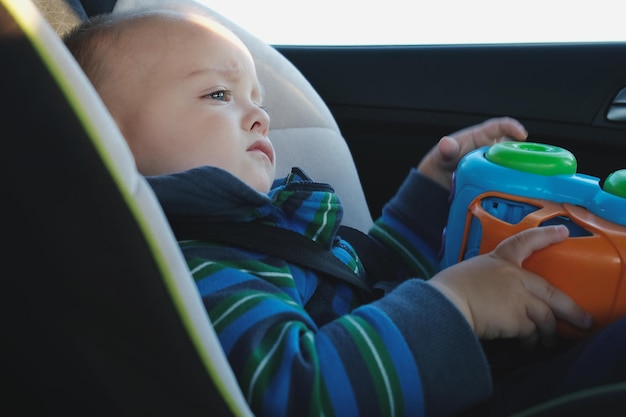 Overstuur baby reist in auto zittend in kinderveiligheidszitje