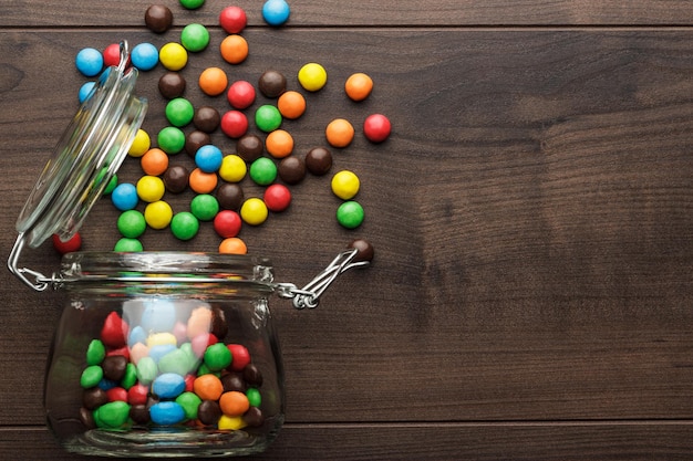 Overturned glass jar full of colorful sweets