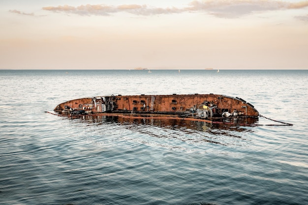 Overturned tanker wreck in the sea. Environment pollution problem