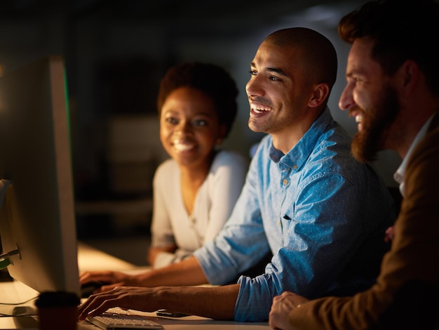 Overuren gemakkelijk maken als een team Bijgesneden opname van een groep collega's die laat op kantoor aan het werk zijn