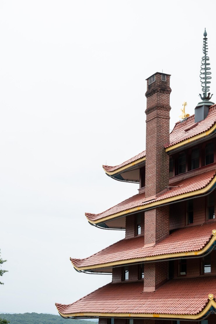 Photo overview of an asian pagoda looking over a forest and city