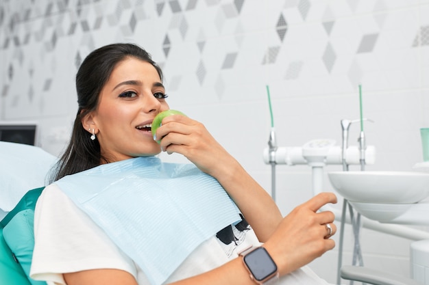 Panoramica della prevenzione della carie dentale donna alla poltrona del dentista durante una procedura dentale bella donna sorriso da vicino