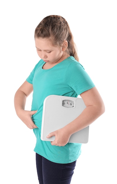 Overweight girl with floor scales on white background