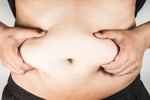 Premium Photo  The overweight and bulky man held his stomach with his  hands and squeezed the fat.