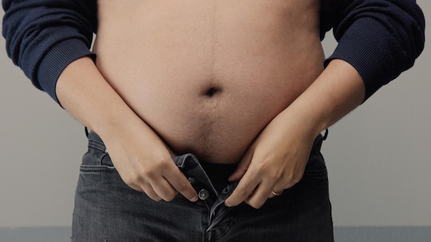 Overweight man closeup of belly side view put up shirt and pinch and clap a belly