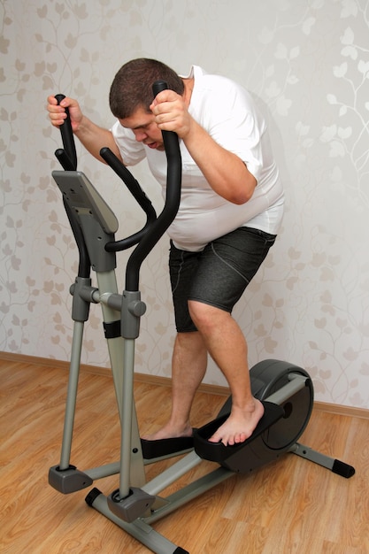 Overweight man exercising on trainer