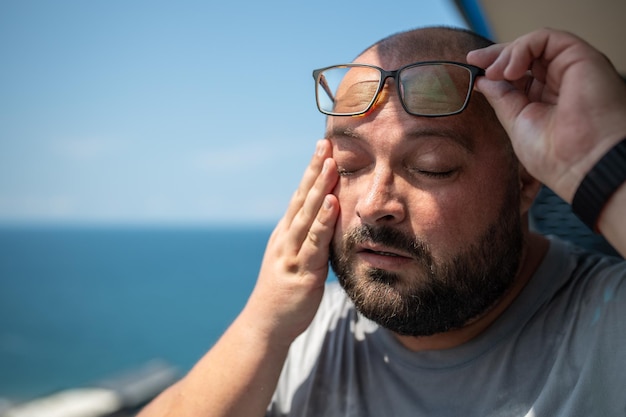 Overweight man wipes sweat face with suffering from summer sun sunstroke abnormally high temperature