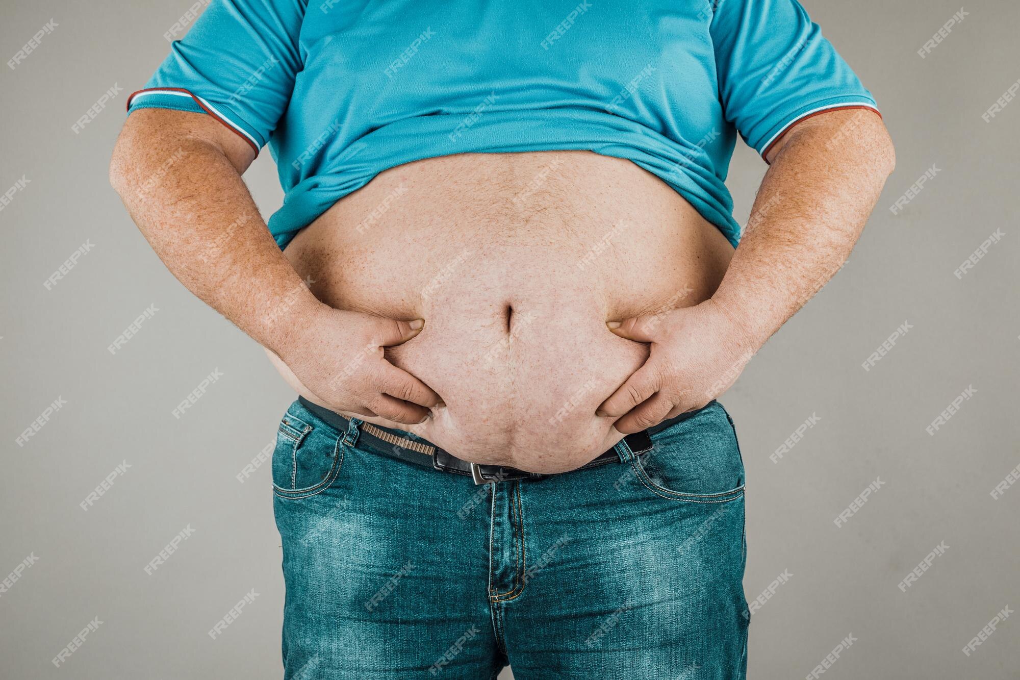 Premium Photo  The overweight and bulky man held his stomach with his  hands and squeezed the fat.