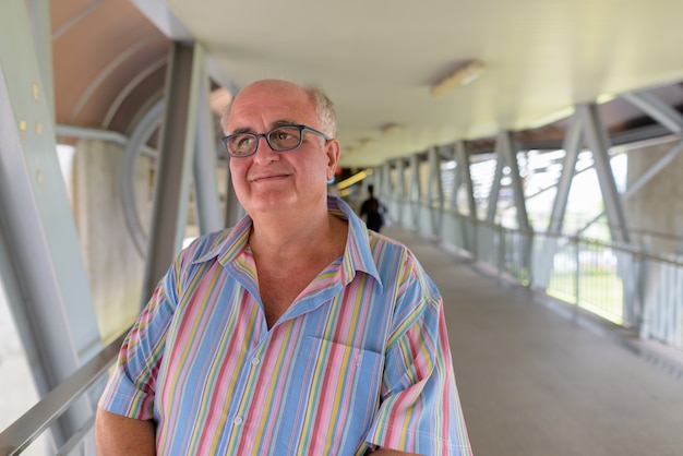 Overweight senior tourist man exploring around the city of Bangk