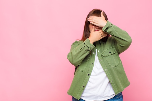 Overweight woman covering face with both hands