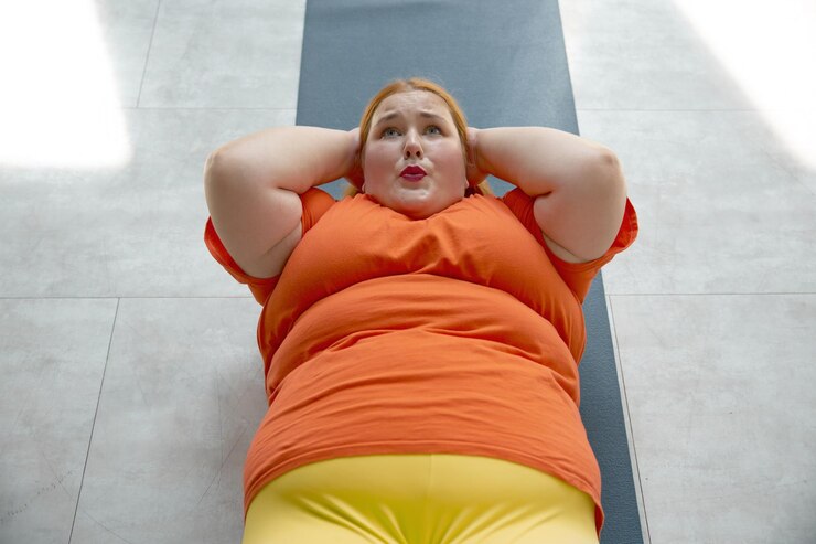 Фотография женщина с избыточным весом занимается abdominal crunch, лежа на коврике. девушка с ожирением занимается фитнес-тренингом в тренажерном зале.