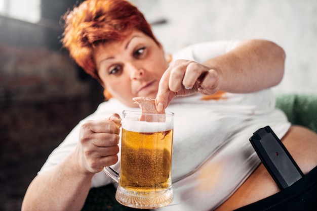 Overweight woman drinks beer, obesity