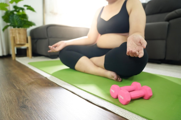 Overweight woman exercising for weight loss exercise with dumbbells in stretching positions at home in the living room Cheerful Fat woman diet healthy lifestyle concept