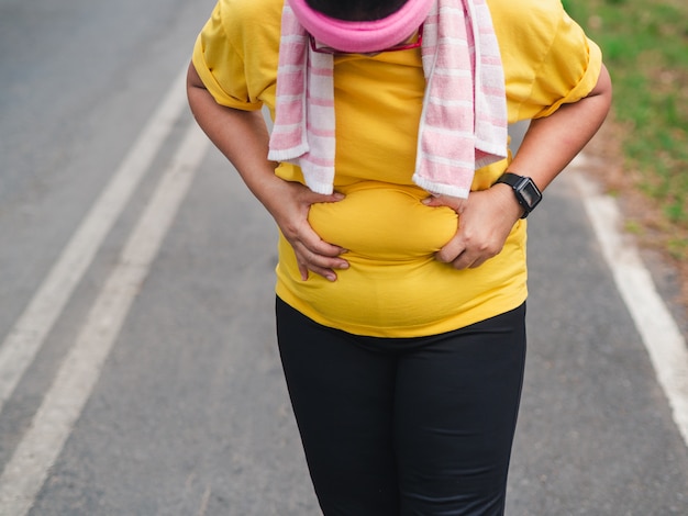 Overweight woman holding her belly. Weight loss concept