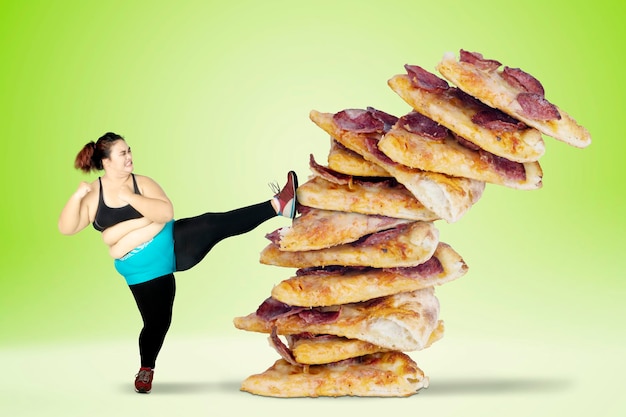 Photo overweight woman kicking pizza