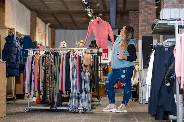 Overweight woman shops in a clothing store in the plus size section