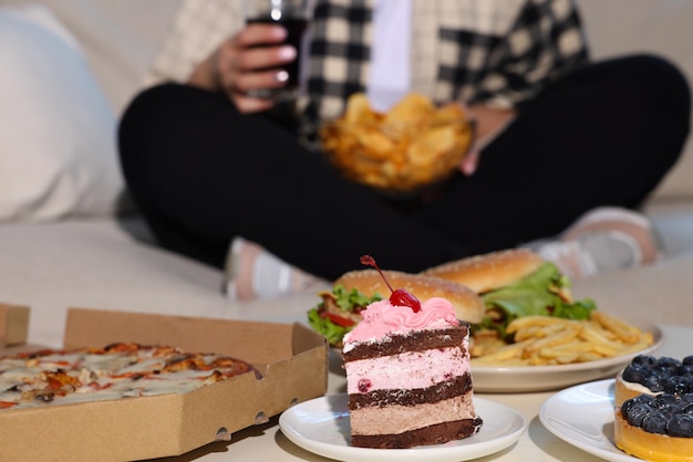 Overweight woman with chips focus on unhealthy food