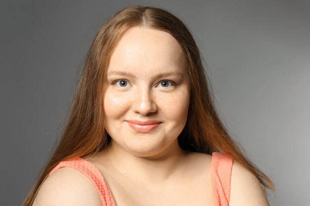 Overweight young woman on gray background Diet concept