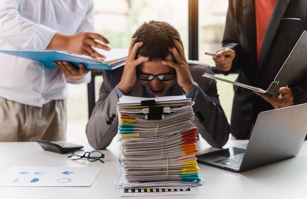 Overwerkte trieste zakenman met stapel papieren zakenmensen deadline stress en papierwerk concept