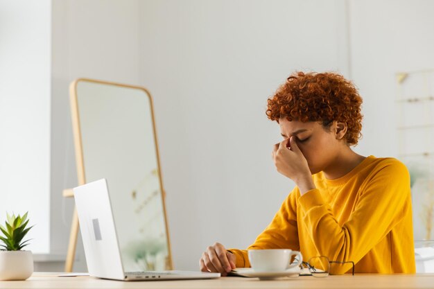 Photo overwhelmed young african woman suffering from dry eyes syndrome eyestrain pain massaging nose