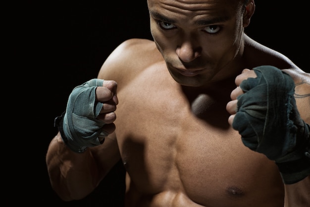 Foto overwin je woede. close-up shot van een jonge professionele vechter poseren op zoek ernstig met zijn vuisten omhoog