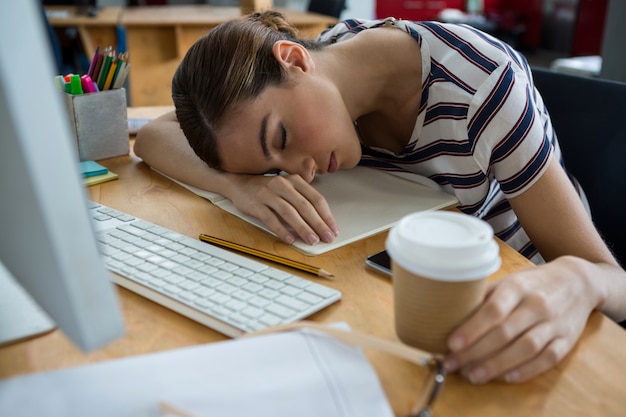 Overworked graphic designer sleeping on his desk