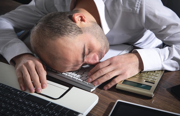 Overworked man sleeping at office.