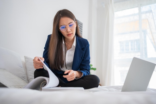 Photo overworked and stressed young asian woman working on laptop computer and document