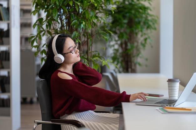 Overworked student woman touch painful neck exhausted work in library preparing for graduation exam