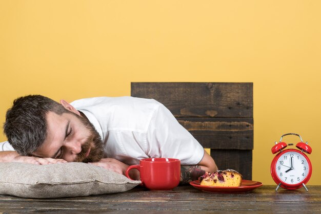 Overworked and tired bearded man sleep at breakfast table on pillow exhausted businessman asleep at