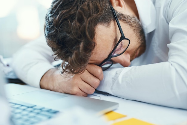 Overworked tired and man sleeping on desk with burnout fatigue and business employee with glasses papers and laptop sleep in office Businessman lawyer and exhausted in company workplace