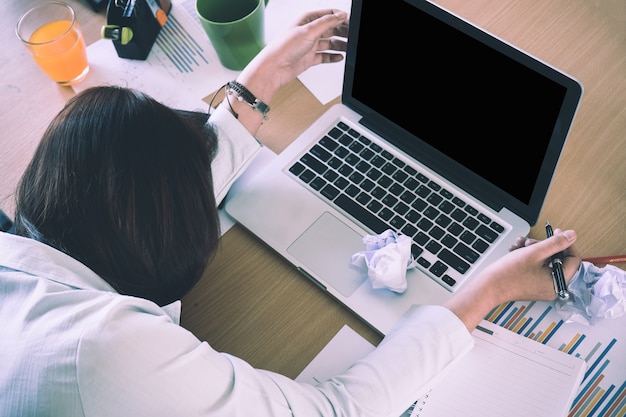 Overworked and tired young woman sleeping on desk