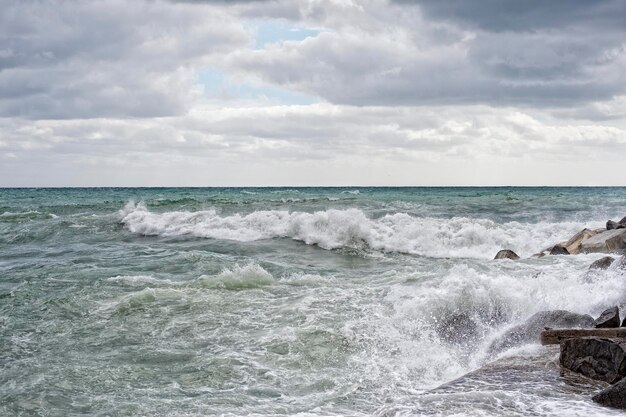 Overzees in storm op rotsen van Italiaans dorp