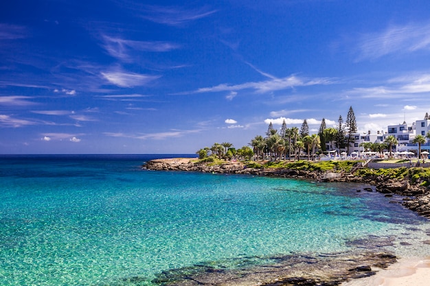 Overzees turkoois water, zandig strand en blauw hemellandschap in Vijgeboombaai, Cyprus.