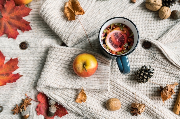 Photo oveview of ripe apple, mug of hot herbal tea with lemon