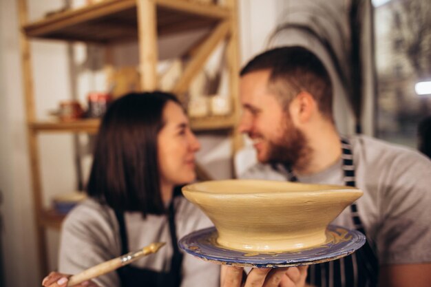 Own cup Young couple feeling satisfied while leaving pottery master class with their own cup