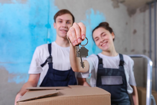 Own home mortgage relocation concept happy couple holding key from new first house family