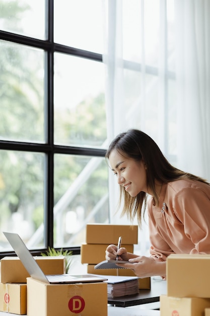 The owner of an online store is checking orders for packaged\
products in order to prepare them for delivery to customers as\
ordered through the website online selling and online shopping\
concepts