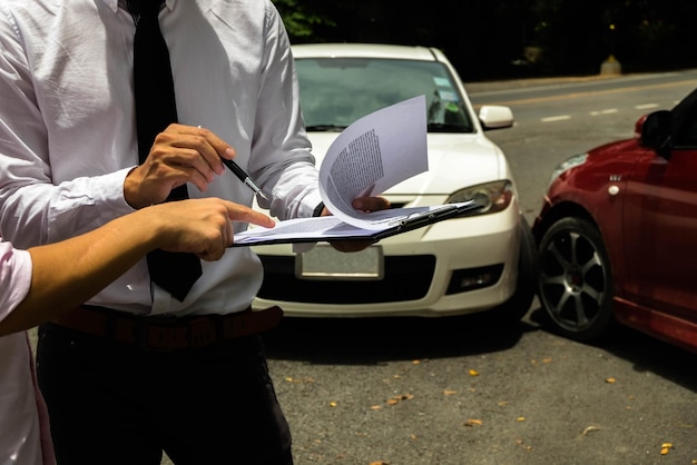 Photo owner pointing on paper with agent against cars