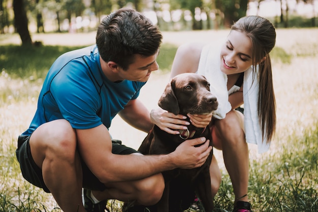 Owners is Smiling and Stroking Their Pet in Green Park