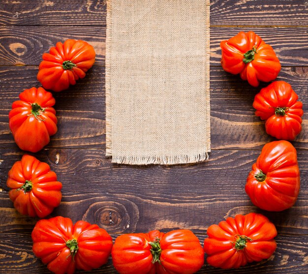 Ox heart tomatoes, on rustic wood background, free space for text.