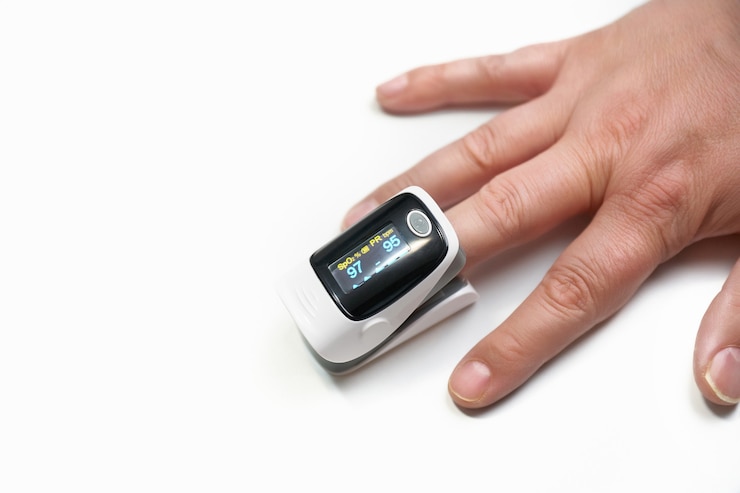 Photo oximeter on finger on white background